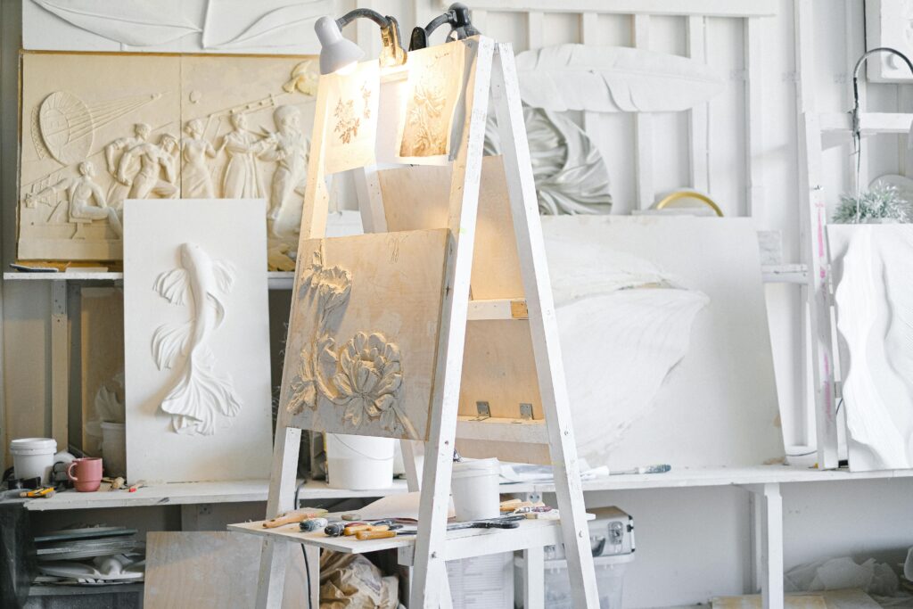 Art studio filled with diverse sculptures, tools, and materials, showcasing creativity and craftsmanship.