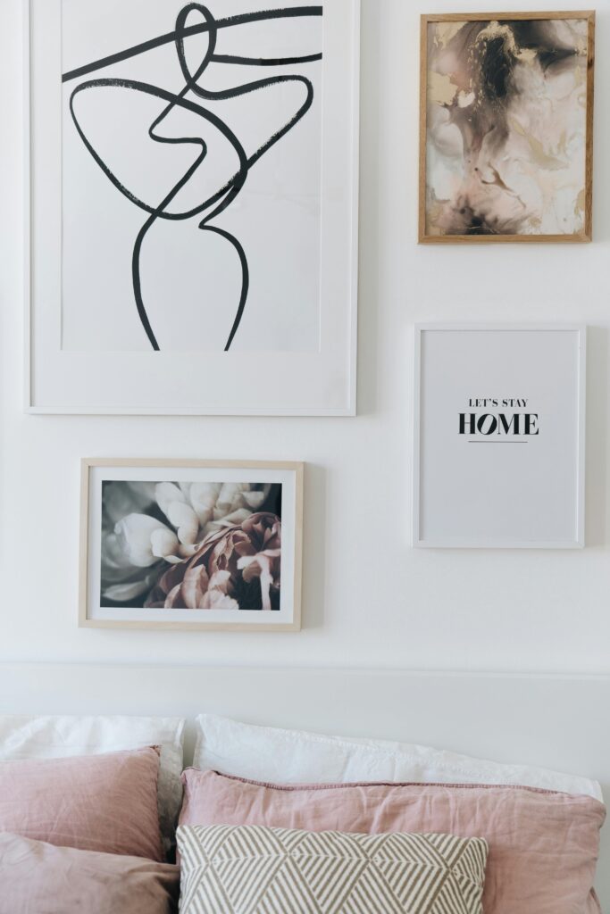 Serene living room featuring abstract art and photo frames on a white wall.